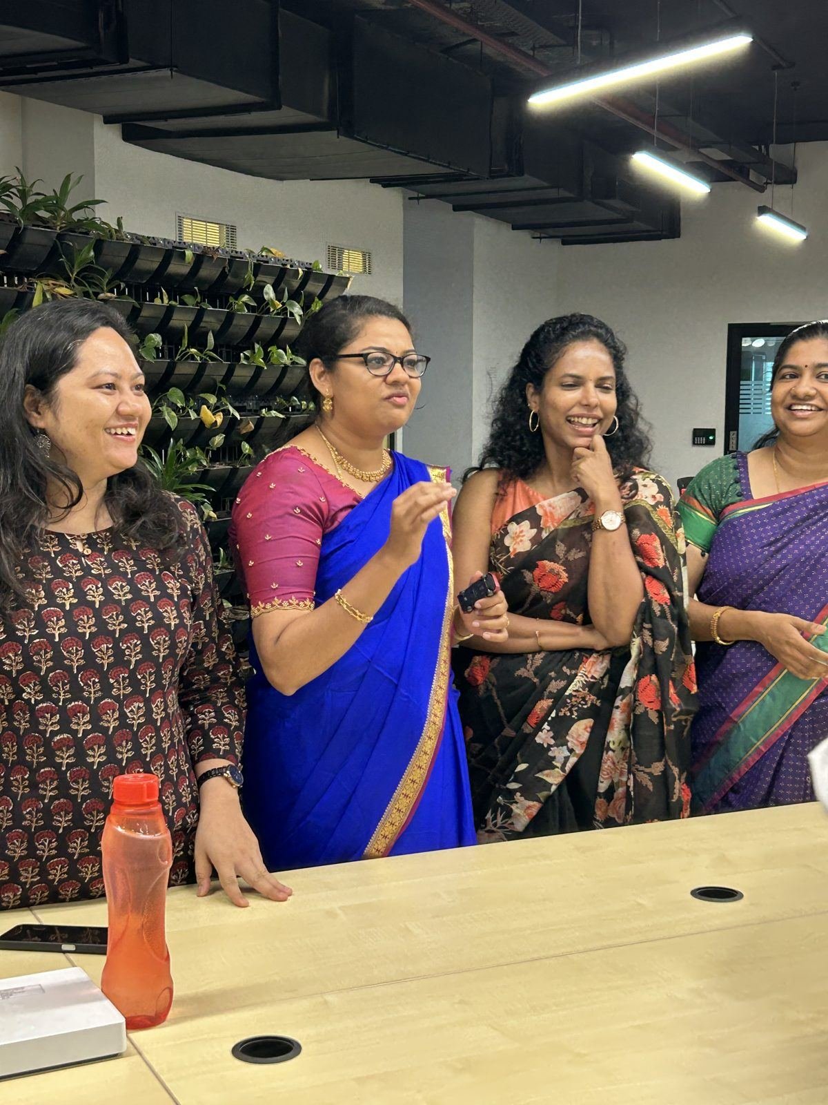 Colleagues in sarees giggling together