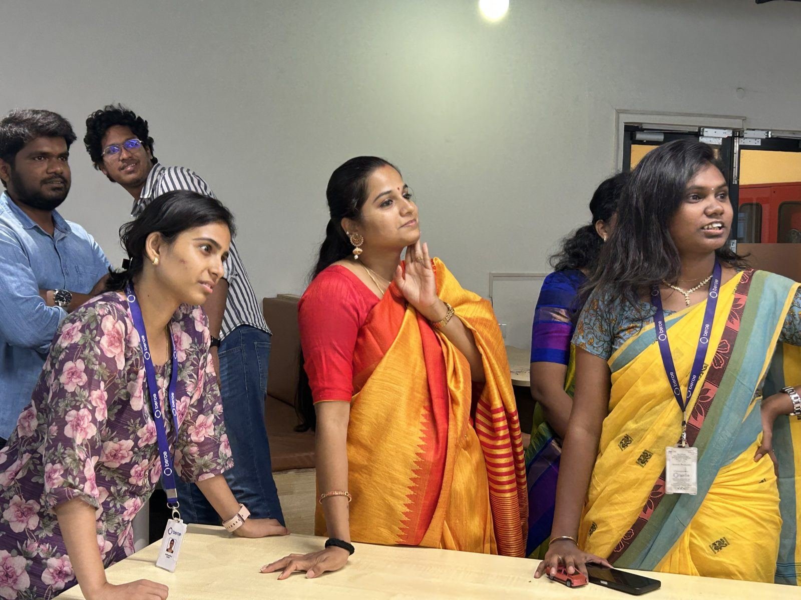 Colleagues in festive sarees sharing a moment