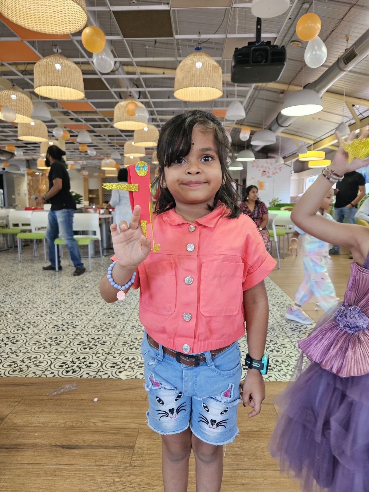A girl proudly holding up her creation