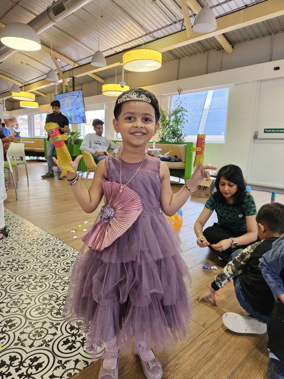 A girl in a party dress showing off her craft