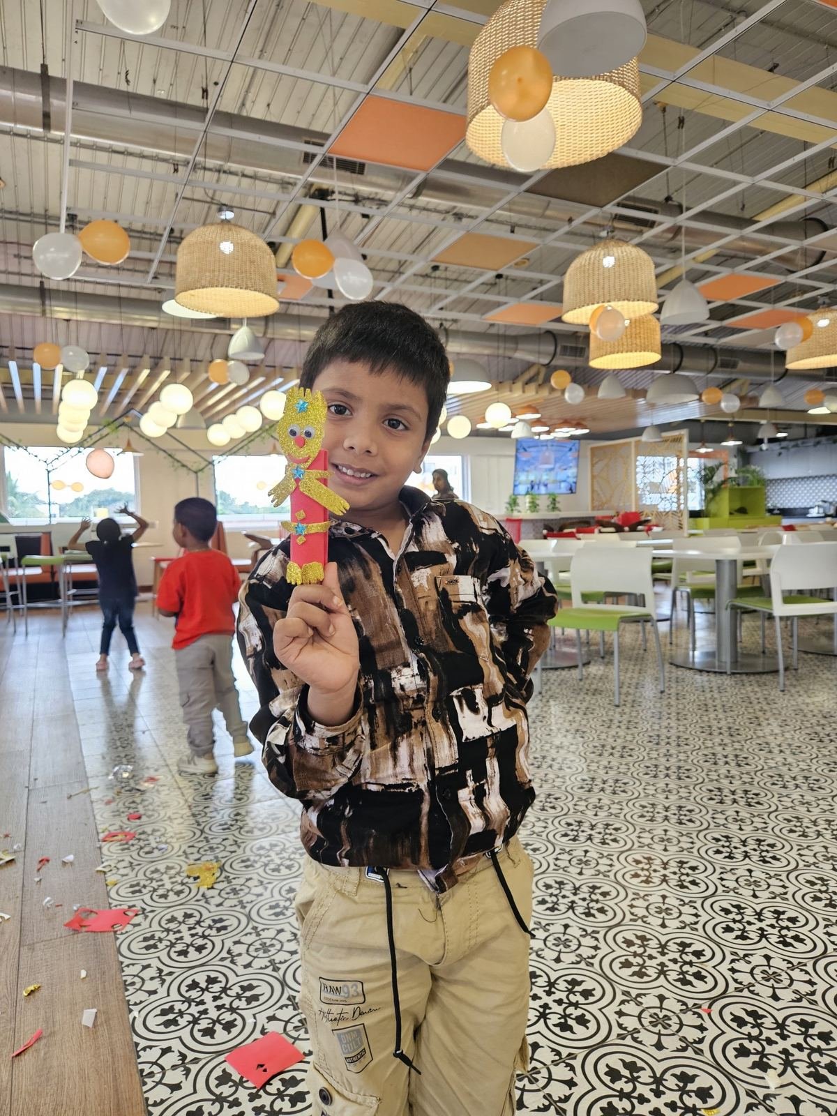 A boy holding up his handmade puppet