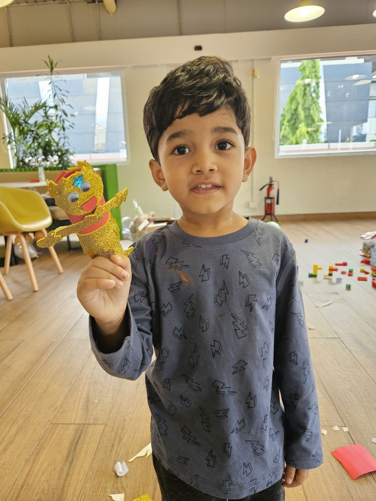 A boy showing the puppet he made