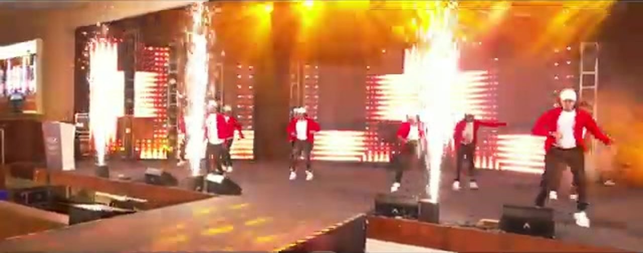 Dancers performing on stage between sparkler fountains at EBSC Day