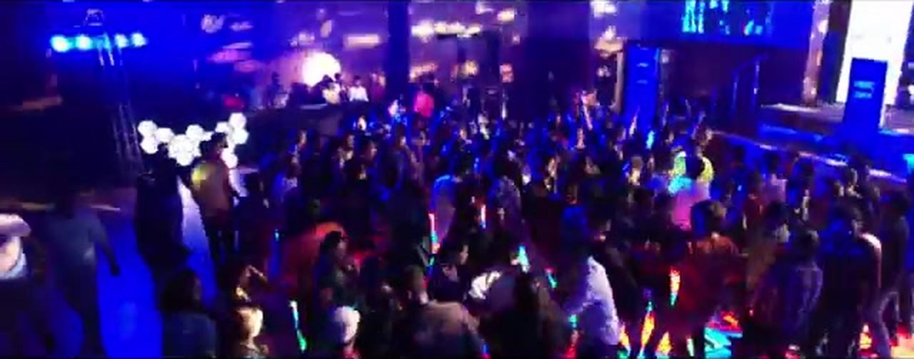 A packed, neon-lit dance floor